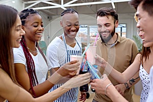 Happy diverse friends cheering with lemonade at barbecue dinner party