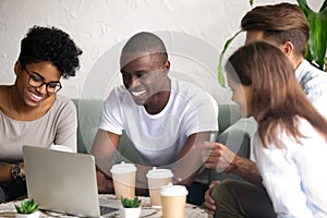 Happy diverse friends laugh hanging out in cafe