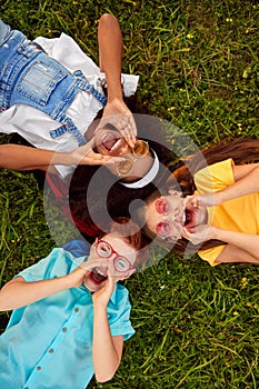 Happy diverse kids lying on grass and screaming