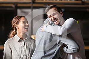 Happy diverse male buddies embracing laughing greeting in cafe