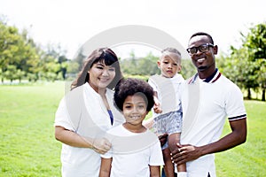 Happy diverse and mixed race family group photo in the park