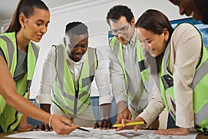 A happy diverse multiracial group of architect colleagues analyzing a blueprint design on a building and discussing