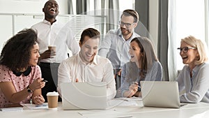 Happy diverse office workers team laughing together at group meeting photo