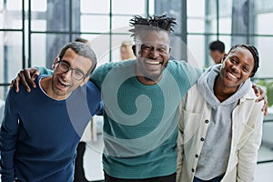 Happy diverse professional business team standing in the office and looking at the camera smiling