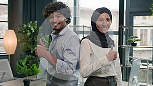 Happy diverse staff employees Arabian Indian man businessman and muslim woman businesswoman in hijab joyful co-workers