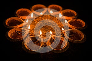 Happy Diwali and circle of Diya - many Terracotta diyas or oil lamps arranged over clay surface or ground in round or circular sha photo