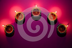 Happy Diwali - Clay Diya lamps lit during Dipavali, Hindu festival of lights celebration. Colorful traditional oil lamp diya on