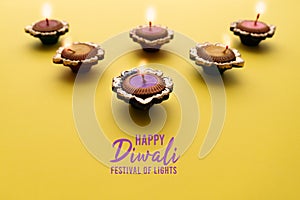 Happy Diwali - Clay Diya lamps lit during Dipavali, Hindu festival of lights celebration. Colorful traditional oil lamp diya