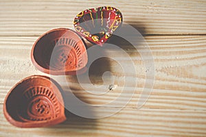 Happy Diwali - Clay Diya lamps lit during Dipavali, Hindu festival of lights celebration.oil lamp diya on wooden background