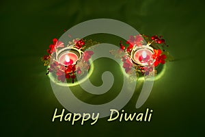 Happy Diwali. Traditional Indian festival green background with burning candles decorated with bright red flowers. Deepavali celeb photo