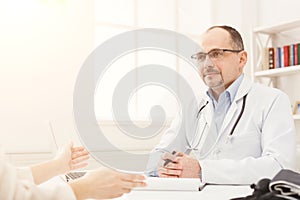 Happy doctor consulting woman in hospital