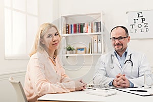 Happy doctor consulting woman in hospital