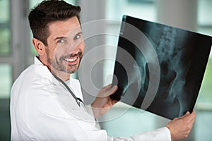 happy doctor examining x-ray images patient