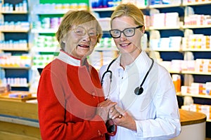 Happy doctor with female patient in pharmacy