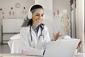 Happy doctor in headphones talking to patient on video call
