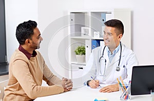 Happy doctor and male patient meeting at clinic photo