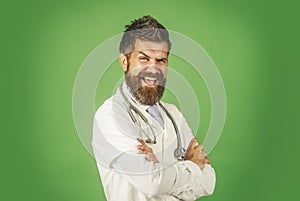 Happy doctor in medical gown with stethoscope on neck. Male physician in white medical robe with folded arms. Smiling