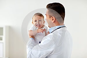 Happy doctor or pediatrician with baby at clinic