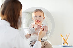 Happy doctor or pediatrician with baby at clinic