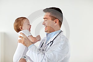 Happy doctor or pediatrician with baby at clinic