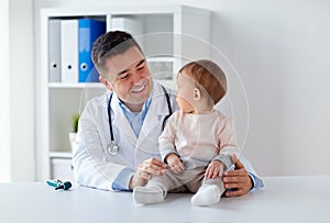 Happy doctor or pediatrician with baby at clinic