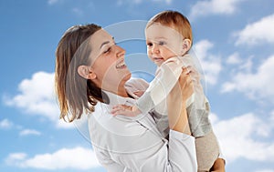 Happy doctor or pediatrician with baby over sky