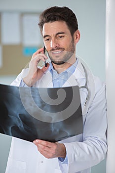 happy doctor on phone with xray