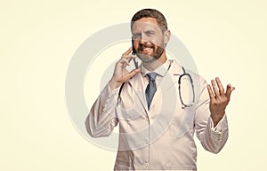 Happy doctor talking on mobile phone. Mobile physician isolated on white. Using mobile technology