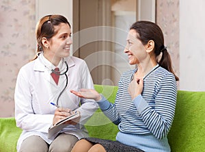 Happy doctor talks mature patient