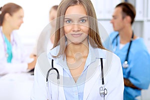 Happy doctor woman with medical staff at the hospital sitting at the table