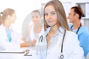 Happy doctor woman with medical staff at the hospital sitting at the table