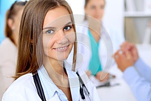 Happy doctor woman with medical staff at the hospital sitting at the table