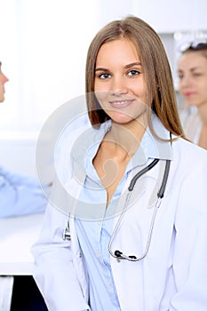 Happy doctor woman with medical staff at the hospital sitting at the table