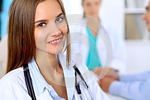 Happy doctor woman with medical staff at the hospital sitting at the table