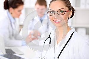 Happy doctor woman with medical staff at the hospital sitting at the table