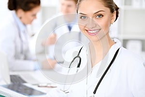 Happy doctor woman with medical staff at the hospital sitting at the table