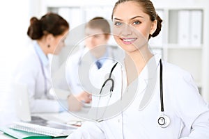 Happy doctor woman with medical staff at the hospital sitting at the table