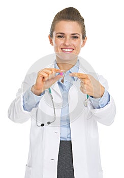 Happy doctor woman pointing on pill