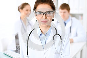 Happy doctor woman with medical staff at the hospital sitting at the table