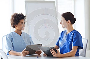 Happy doctors with tablet pc meeting at hospital