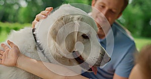 Happy dog enjoy caressing on picnic close up. Smiling man fondle white pet.