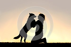 Happy Dog Jumping up to Greet Woman Silhouette