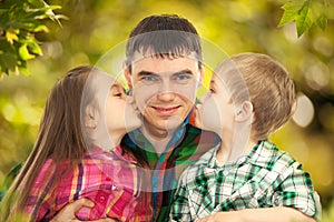 Happy doughter and son kissing their father photo