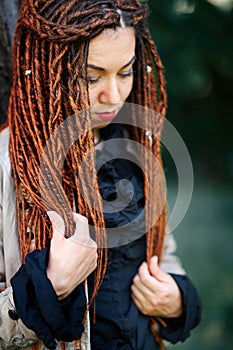 Happy dreadlocks fashionable girl posing in forest