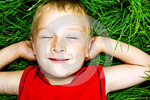 Happy dreaming child on fresh grass