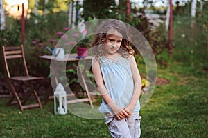 happy dreamy kid girl playing in summer garden
