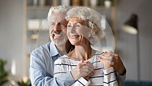 Happy dreamy older mature spouses visualizing future together. photo