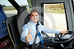 Happy driver driving bus and snowing thumbs up