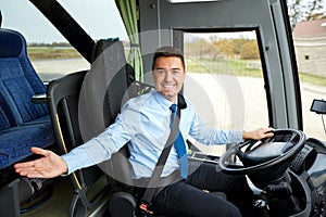 Happy driver inviting on board of intercity bus photo