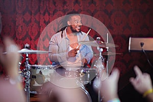 Happy drummer performing on stage at nightclub